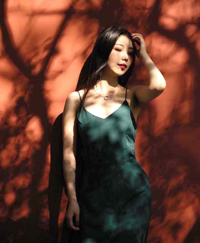 A photo of a Chinese woman against a reddish backdrop