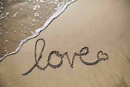 the word love written on the sand