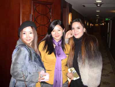 three beautiful Chinese women smiling and standing in a hallway