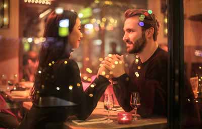 Couple holding hands across a table.